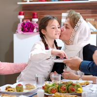 Une maman embrasse sa petite fille en partageant un repas